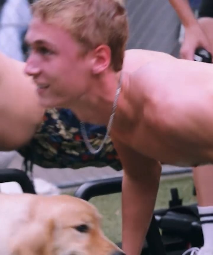Shirtless pushups next to a golden retriever at a wellness darty