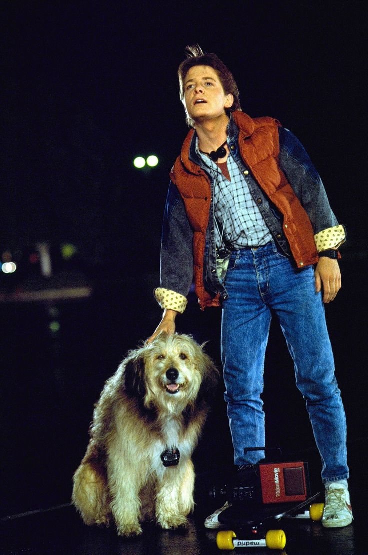 a man on a skateboard next to a dog