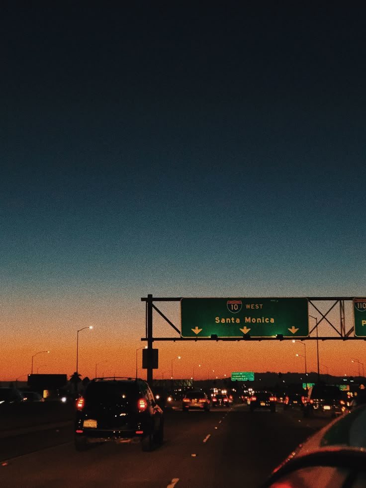 an exit sign on a highway at dusk