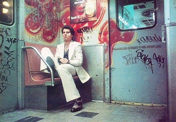 a man on a graffiti covered subway car
